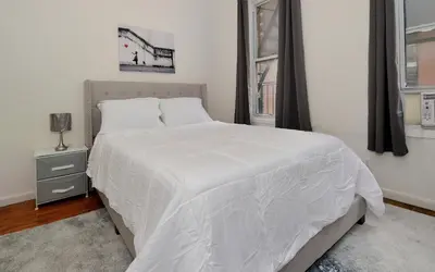 a white bed in a bedroom with a window at Cozy Studio Steps to Central Park Upper E Side in New York