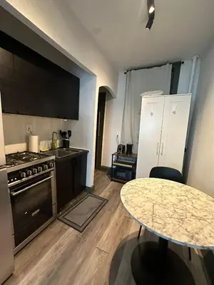 a kitchen with a table and a stove and a counter at Cozy 2BR in NYC Lenox Hill in New York