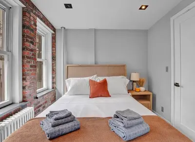 a bedroom with a bed with towels on it at Midtown West Furnished Apartment 3BR in New York