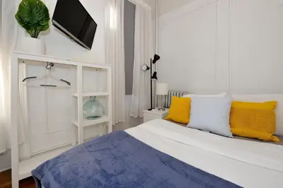 a bedroom with a bed with yellow and blue pillows at Midtown West Furnished Apartment 3BR in New York