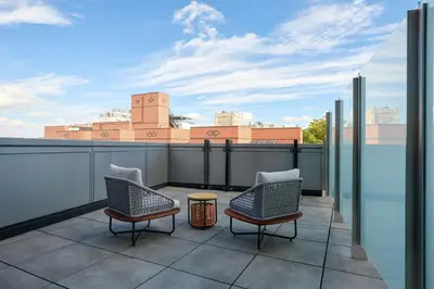 a patio with two chairs and a table on a roof at The Westin Flushing LaGuardia Airport in Flushing