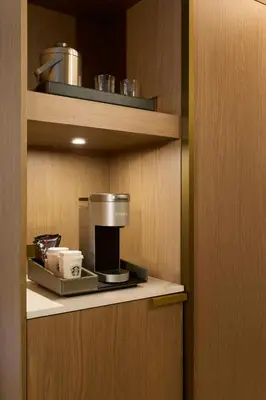 a kitchen with a coffee maker on a shelf at The Westin Flushing LaGuardia Airport in Flushing