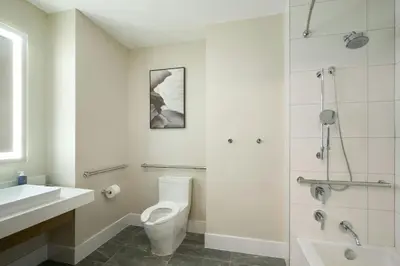 a white bathroom with a toilet and a shower at The Westin Flushing LaGuardia Airport in Flushing