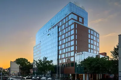 a tall glass building with a lot of windows at The Westin Flushing LaGuardia Airport in Flushing