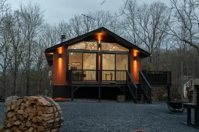 a small house with a large window and a staircase at Modern Retreat Poconos 3BR Fire Pit Skiing in East Stroudsburg