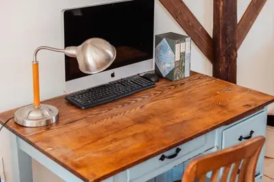 a desk with a computer and a lamp on it at Light-filled Carpenter's Cottage in Stockbridge in Stockbridge