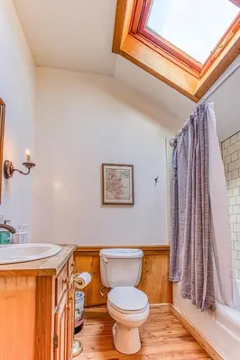 a bathroom with a toilet and a sink and a window at Light-filled Carpenter's Cottage in Stockbridge in Stockbridge