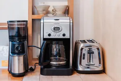 a coffee maker and a blender on a shelf at Light-filled Carpenter's Cottage in Stockbridge in Stockbridge