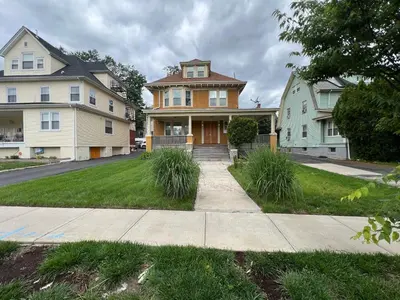 a group of houses on the side of a street at The Grand Parkway is a unique getaway with charm! in East Orange