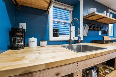 a kitchen with a sink and a blue wall at The Hygge Way, 20MIN TO NYC Times Sq in North Bergen