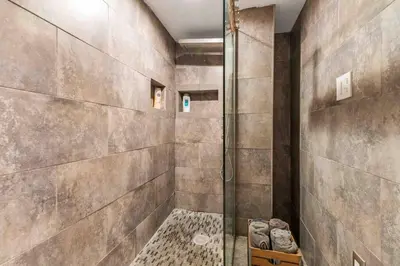 a shower with a glass door in a bathroom at The Hygge Way, 20MIN TO NYC Times Sq in North Bergen