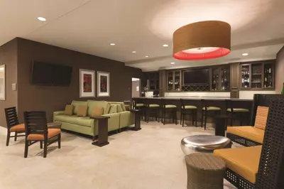 a living room with a green couch and a bar at Hilton Garden Inn Wallingford/Meriden in Wallingford