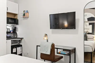 a room with a desk and a tv on a wall at Micro Studio Walk to Time Square in New York