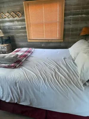 a large white bed in a room with a window at The Cabins at Walnut Grove-minutes from Hunter and Windham in Ashland