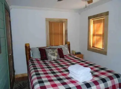 a bedroom with a bed with a checkered blanket at The Cabins at Walnut Grove-minutes from Hunter and Windham in Ashland