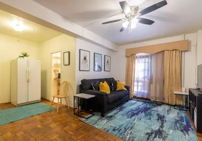 a living room with a couch and a ceiling fan at Sunny Fully Furnished Studio in Chelsea in New York