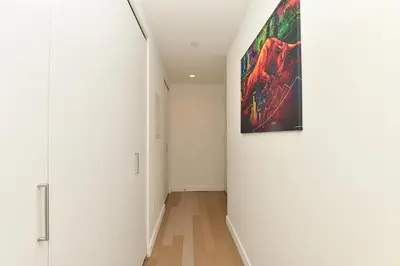 a hallway with white walls and a painting on the wall at The Wolf of Wall Street Apartment in New York