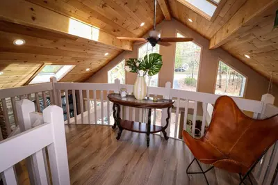 a room with a table and a ceiling fan at Villa MiaNova A Modern Hideout in the Woods in Lake Ariel