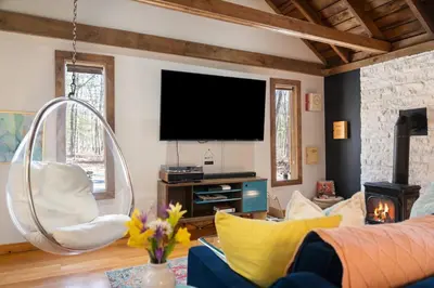 a living room with a flat screen tv and a couch at Perfect Couples Cabin Fireplace Firepit & Wine Nearby in Hawley