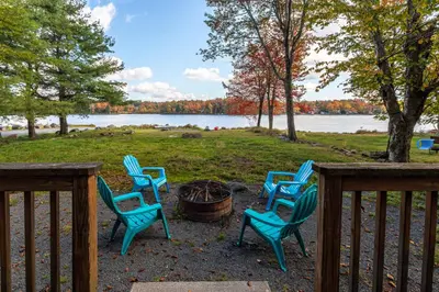 a group of chairs sitting around a fire pit at Boardwalk Chalet Lakefront Fire Pit Pet Frie in Tobyhanna