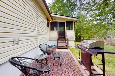 a backyard with chairs and a grill and a house at Sage Grove Sanctuary 3BD Hot Tub Fire Pit in East Stroudsburg