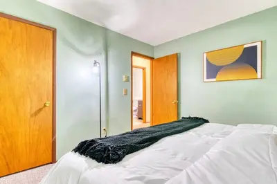 a bedroom with a bed with a black blanket on it at 4BDR Hot Tub Game Room in Lake Ariel