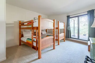 two bunk beds in a room with a window at Whispering Pines Chalet Game Room Fire Pit in Pocono Pines