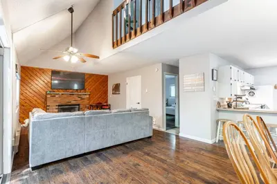 a living room with a gray couch and a kitchen at Cozy 3Br Fire Pit Hammock 2 Minutes to Beach in East Stroudsburg