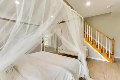 a bedroom with a bed with a mosquito net at Spacious 6 Bedroom Home with NYC Access & Parking! in Newark