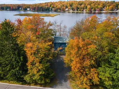 an aerial view of a lake with trees and a house at Tranquil Shores Waterfront Fire Pit Hammock in Tobyhanna