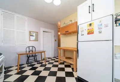a kitchen with a white refrigerator and a checkered floor at Charming 3-Bedroom Apartment in Midtown West in New York