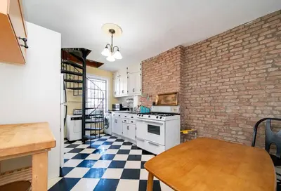 a kitchen with white appliances and a brick wall at Charming 3-Bedroom Apartment in Midtown West in New York