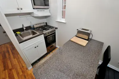 a small kitchen with a stove and a sink at Charming 1BR in Murray Hill Kips Bay - Perfect for 2 in New York