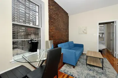 a living room with a blue couch and a glass table at Charming 1BR in Murray Hill Kips Bay - Perfect for 2 in New York