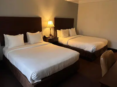 a hotel room with two beds and a lamp at Hamden Hotel and Suites HAMDEN - NEW HAVEN in Hamden