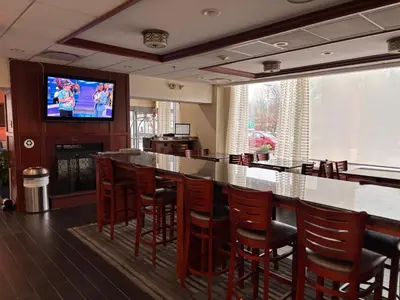 a bar with chairs and a television in a restaurant at Hamden Hotel and Suites HAMDEN - NEW HAVEN in Hamden