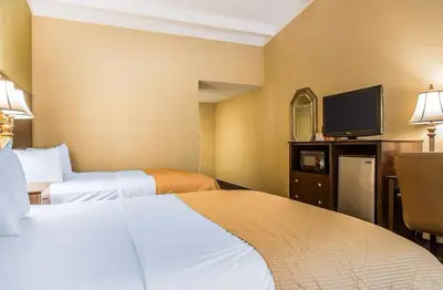 a hotel room with two beds and a flat screen tv at Hamden Hotel and Suites HAMDEN - NEW HAVEN in Hamden