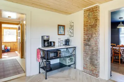 a room with a counter with a microwave and a brick wall at 4 Mi to Great Barrington Berkshires Retreat! in Sheffield