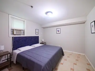 a bedroom with a blue bed and a window at Spacious 2BR Apartment in Jersey City - Easy NYC Access in Jersey City