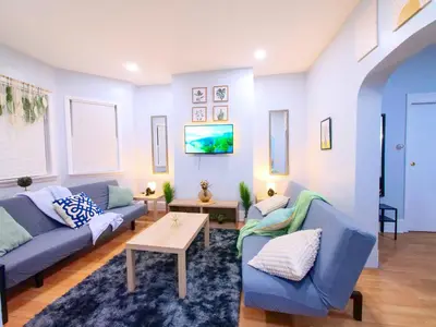 a living room with two blue couches and a table at NYC Views & Comfort - Modern 2-Bedroom Apartment in Jersey City