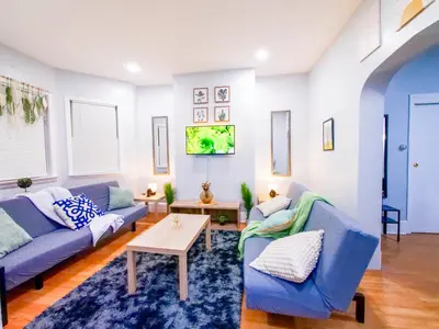 a living room with two blue couches and a table at NYC Views & Comfort - Modern 2-Bedroom Apartment in Jersey City