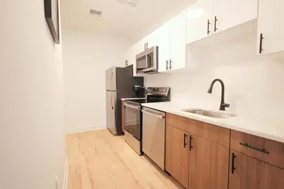 a kitchen with stainless steel appliances and wooden cabinets at The Platinum Downtown Stamford Studio Getaway in Stamford