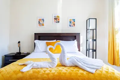 two swans towels are sitting on a bed at Family Apt: 2BR FREE Parking Airprt City Links in Newark
