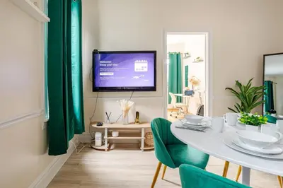 a dining room with a table and a tv on a wall at 6-Guest Jersey City Haven: Location-Comfort-Vibes in Jersey City