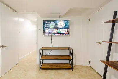 a room with a table and a screen on the wall at Big City Life: 1BR Apt wNetflix Easy NYC Access in Jersey City