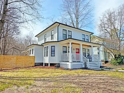 a white house with a red door at Renovated home seconds from town in Woodstock