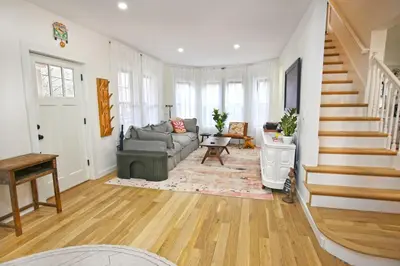 a living room with a couch and a stair case at Renovated home seconds from town in Woodstock