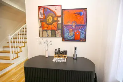 a table in a room with paintings on the wall at Renovated home seconds from town in Woodstock