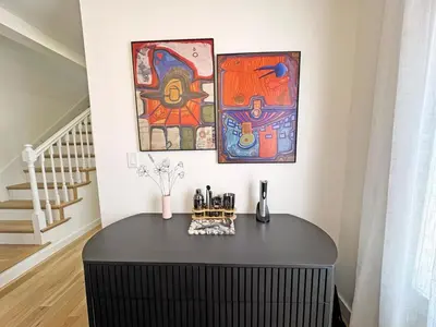 a black table in a room with paintings on the wall at Renovated home seconds from town in Woodstock