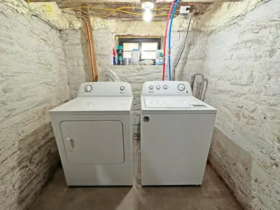 two white washers and a stove in a room at Renovated home seconds from town in Woodstock